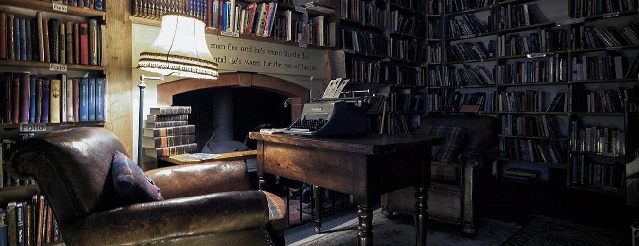 Interior of The Bookshop, Wigtown. Armchair by fireplace, bookshelves and lamp. Antiquarian and second hand books.