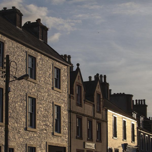 On Main Street, Wigtown, Scotland's National Book Town, in late afternoon sunshine. Older buildings and a telegraph pole.