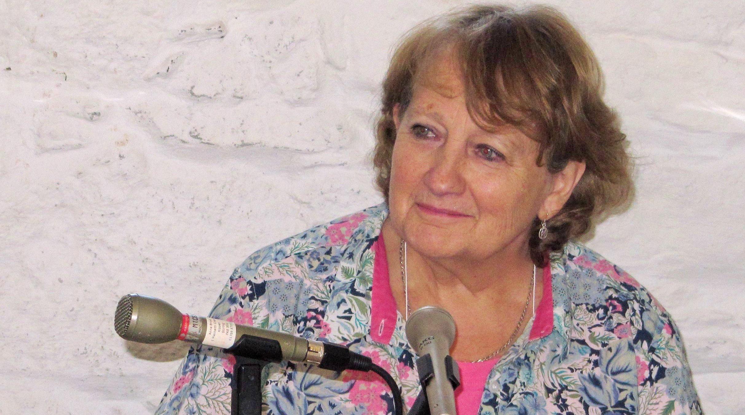 Anne Brown sitting in front of microphones whilst being interviewed.