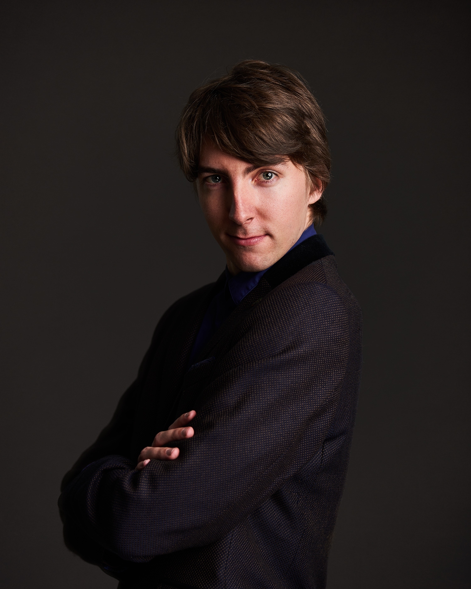 Headshot of children's author Jack Meggitt-Phillips. He stands smiling with his arms folded.