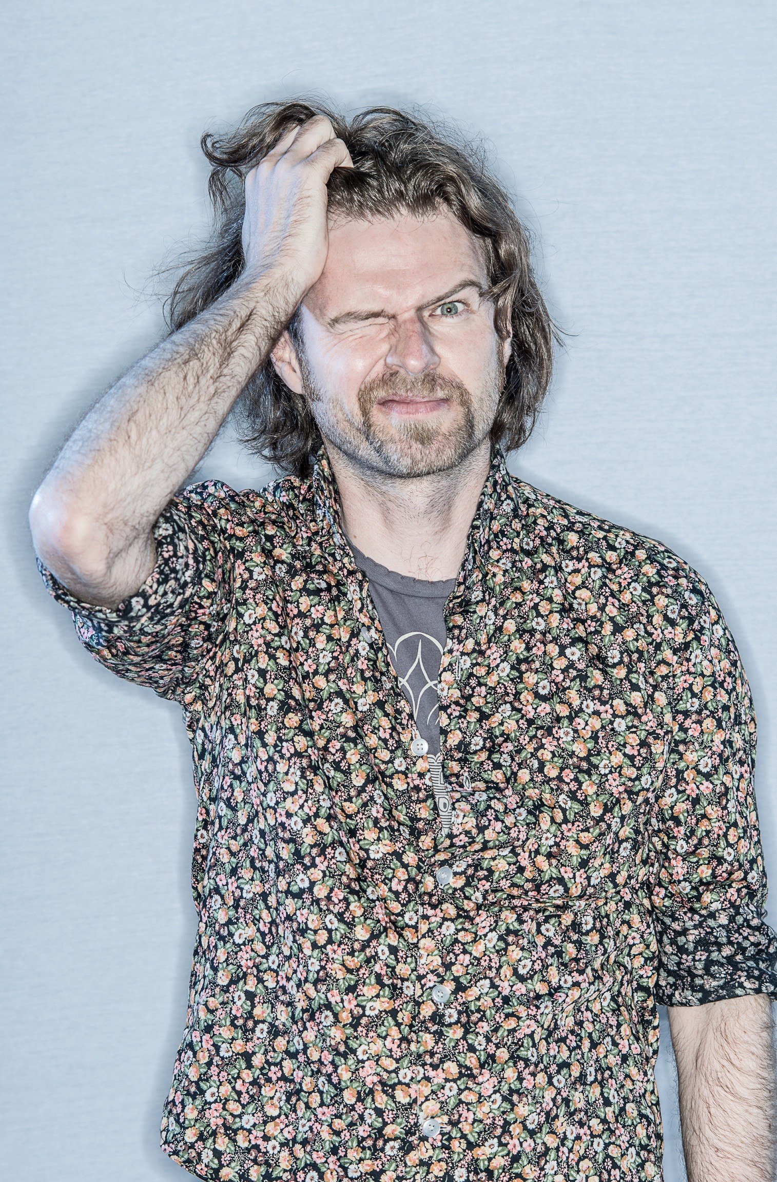 Headshot of Ross Collins pushing his hand through his hair.