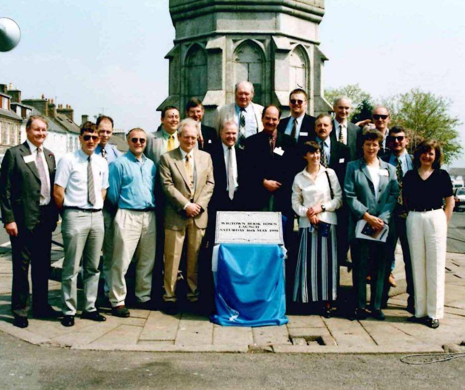 Group of people standing in front of Mercat Cross, Wigtown to celebrate Wigtown Book Town launch on Saturday 16th May 1998.