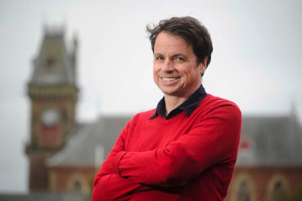 Adrian Turpin, Artistic Director of the Wigtown Festival Company stands in front of Wigtown County Buildings.