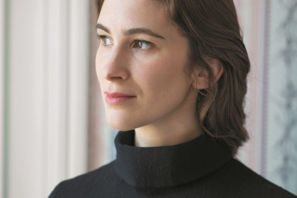 Wigtown Book Festival author Katherine Rundell standing looking away from the camera in front of a window.