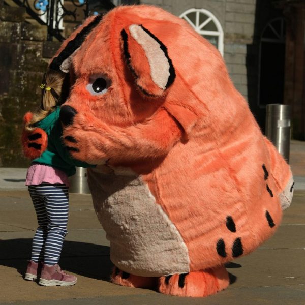 Big DoG meeting a young fan. The orange mascot is giving a child a hug.