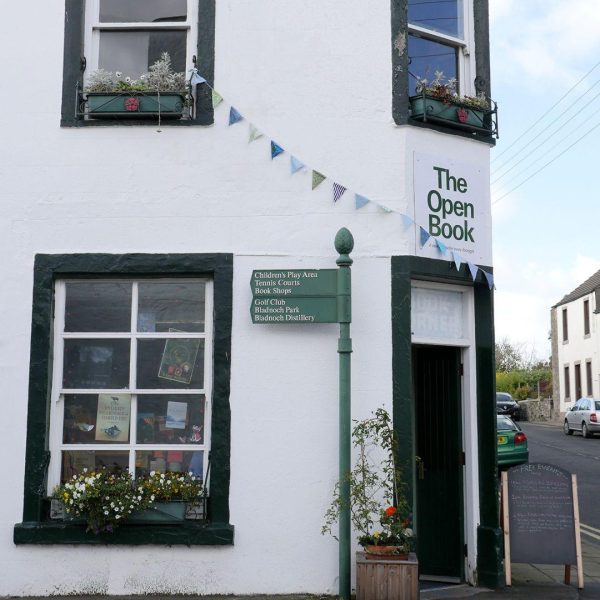 Outside The Open Book, Wigtown, a secondhand bookshop in an old building painted black and white.