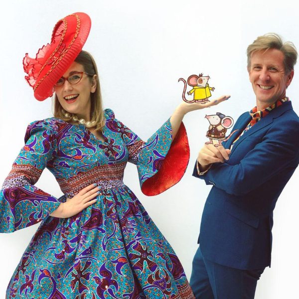 Children's Book Festival authors Philip Reeve and Sarah McIntyre pose in brightly coloured clothes, each holding a cartoon mouse in their hands.