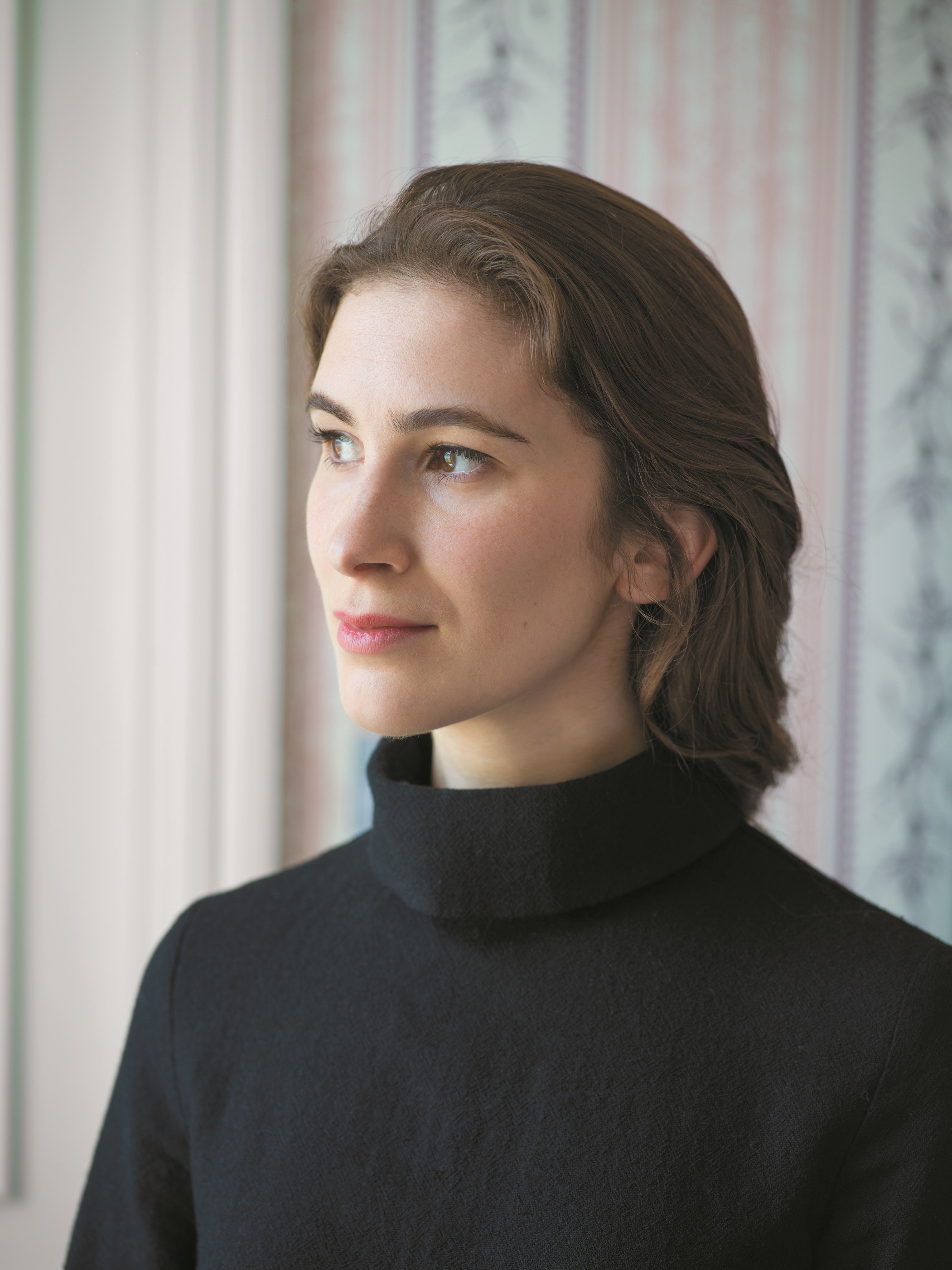 Wigtown Book Festival author Katherine Rundell standing looking away from the camera in front of a window.